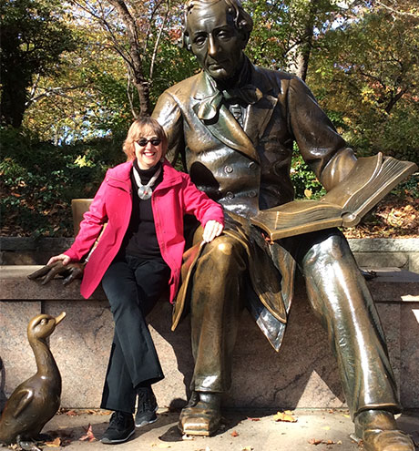 photo of Frieda Wishinsky beside statue of Hans Christian Anderson in Central Park, New York City